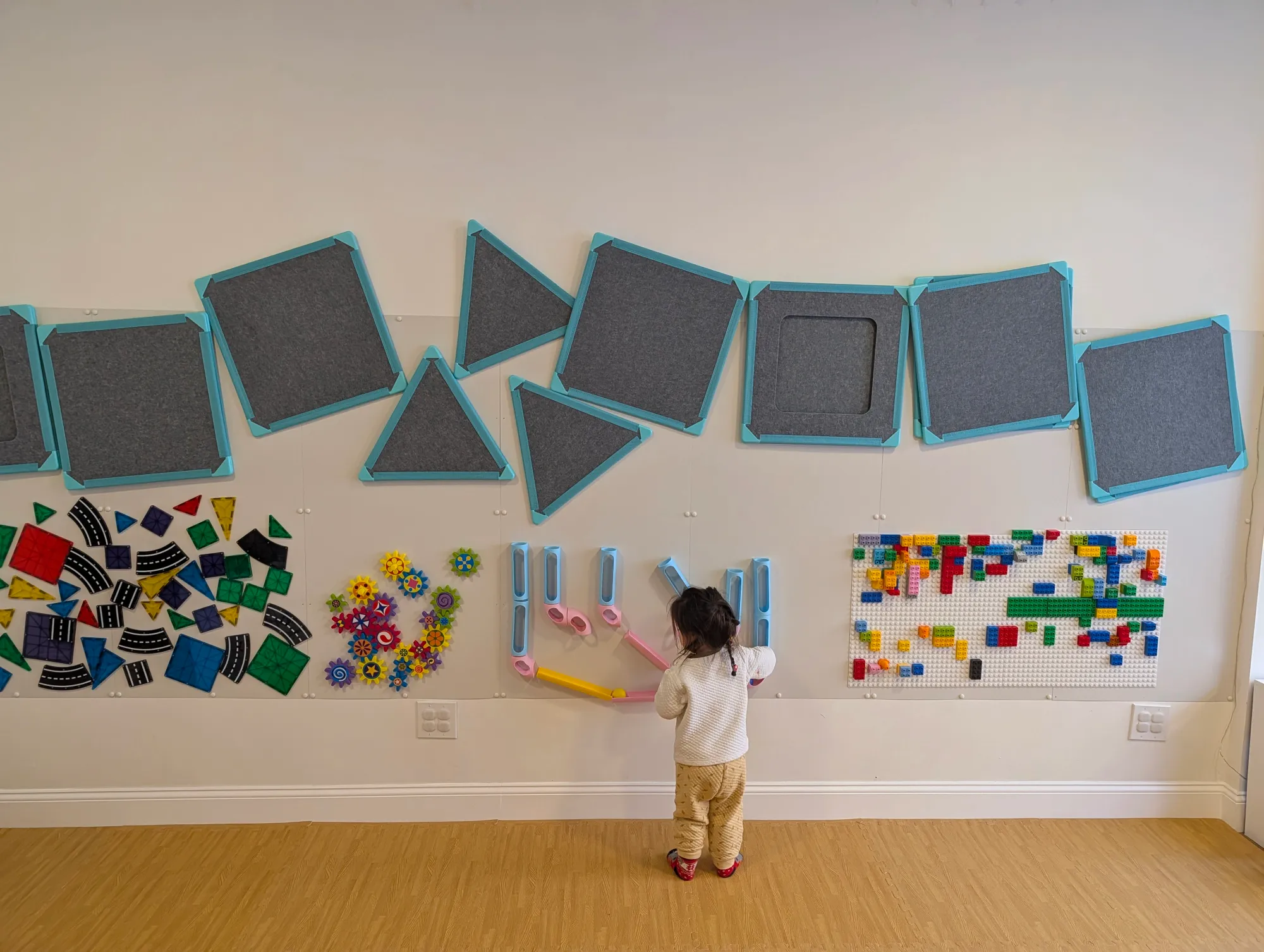 A child happily drawing on the wall at Cortelyou Music & Play